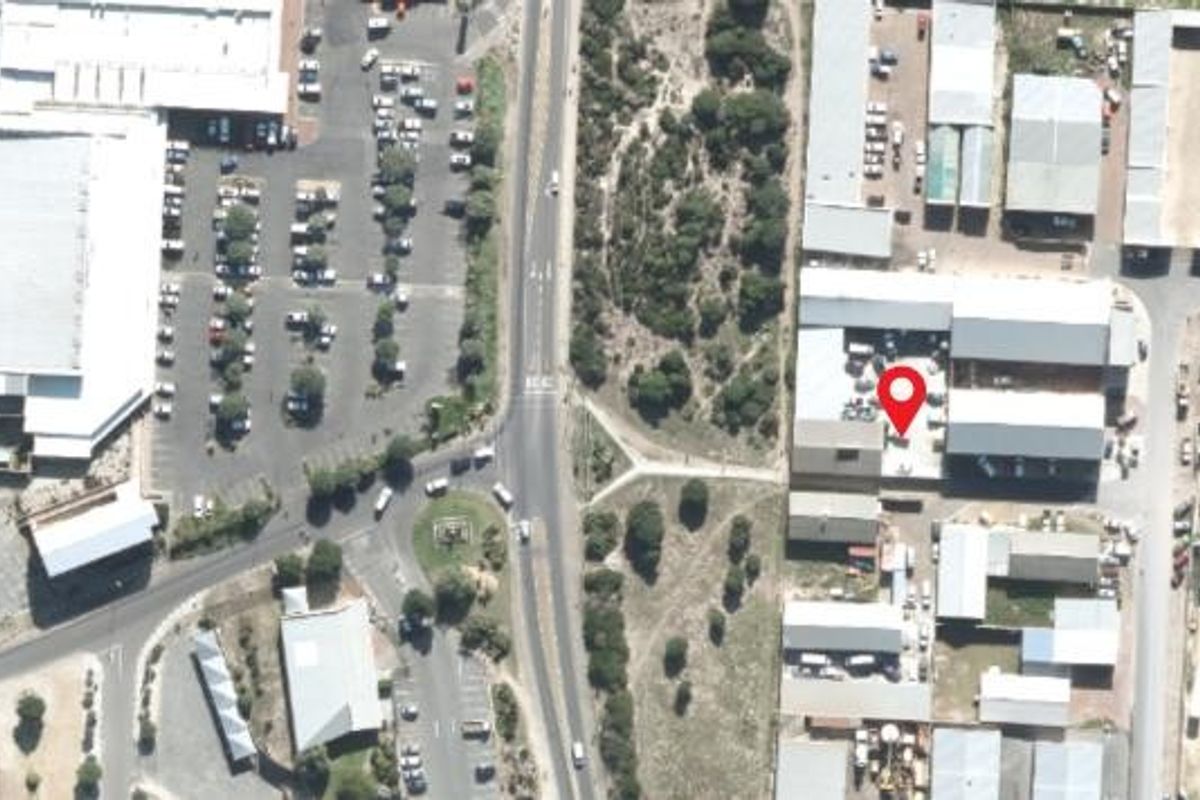 Aerial view of the mixed-use property location, showing surrounding infrastructure, parking areas, and access roads.