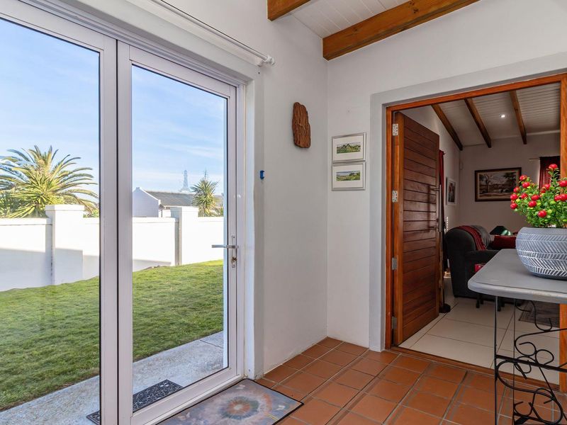 A covered patio area featuring tiled flooring and exposed timber ceiling beams, providing direct access to the garden and interior living space.