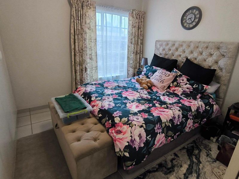 A bedroom featuring tiled flooring and a built-in wardrobe, offering a functional space with natural light from the window.