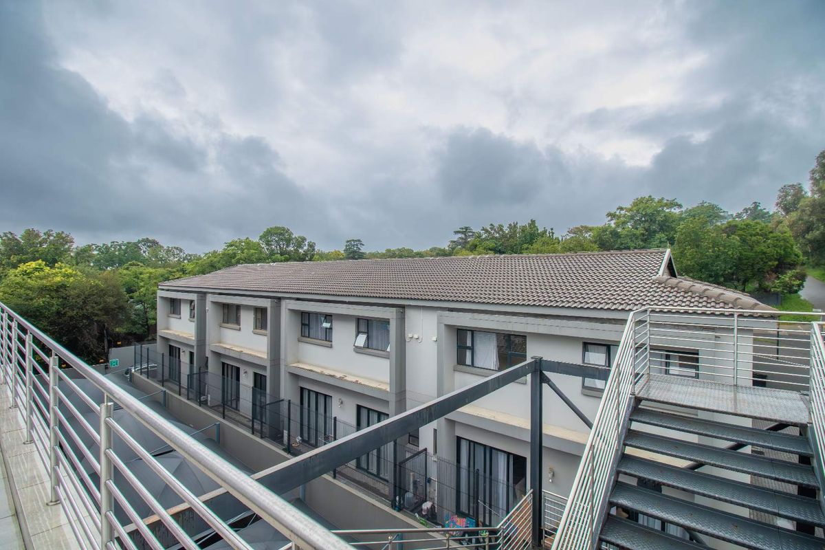 Exterior view of the penthouse complex featuring modern architectural design, tiled roofing, and external metal staircases.