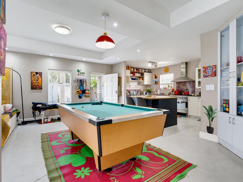 Spacious open-plan living area featuring a modern kitchen with a central island, built-in cabinetry, and integrated display storage, seamlessly flowing into the entertainment space.
