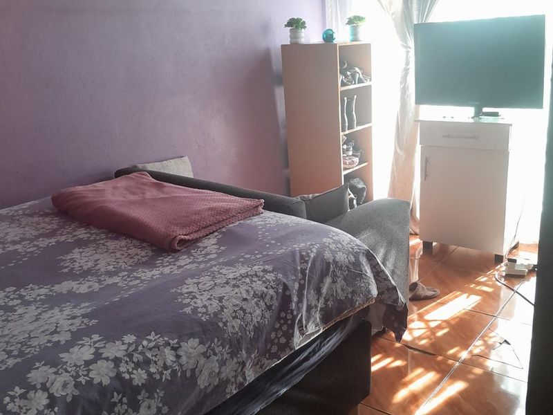 A bedroom featuring tiled flooring with visible damage, requiring maintenance or replacement to improve the overall condition of the space.