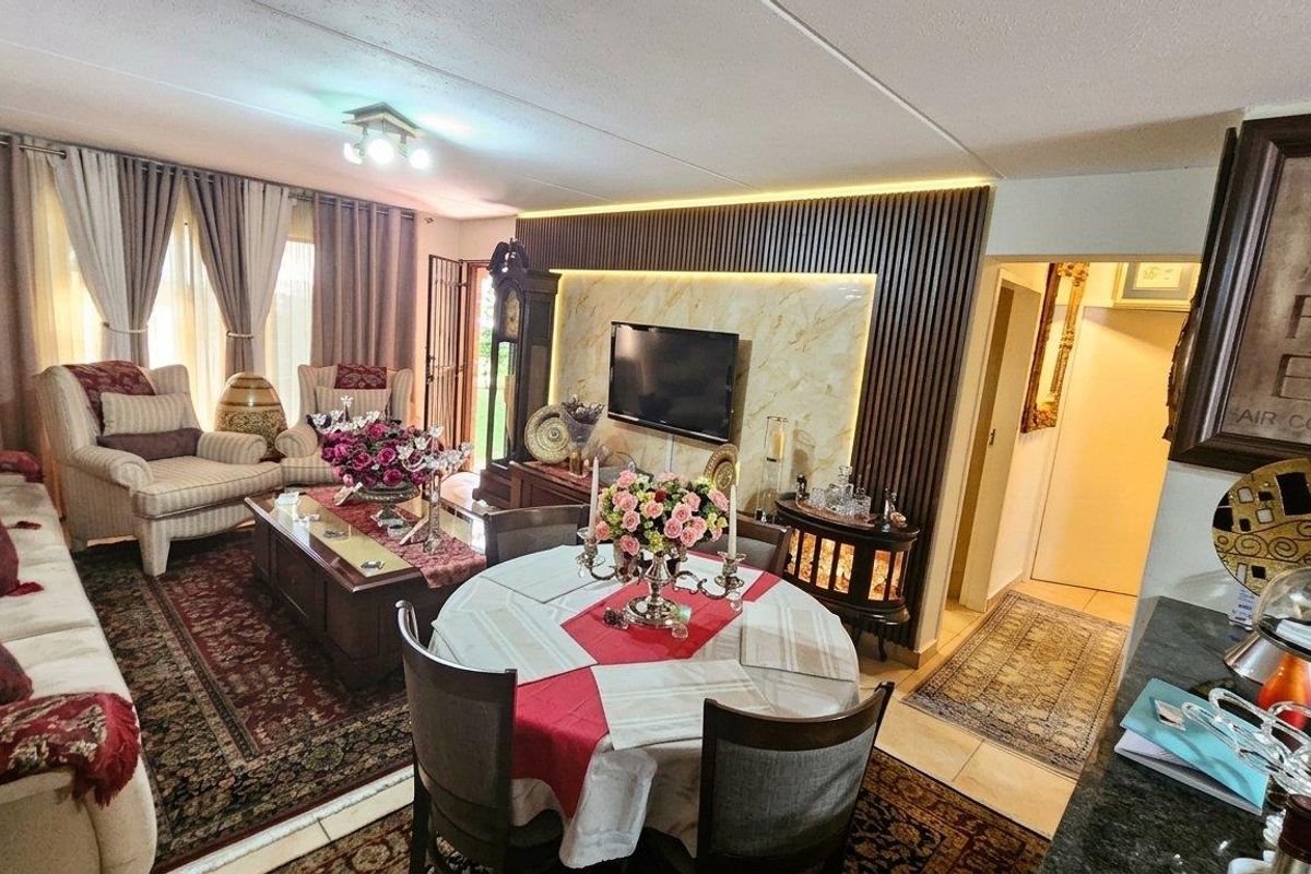 Spacious open-plan living and dining area featuring a modern slatted wood feature wall with integrated lighting and marble-look paneling.