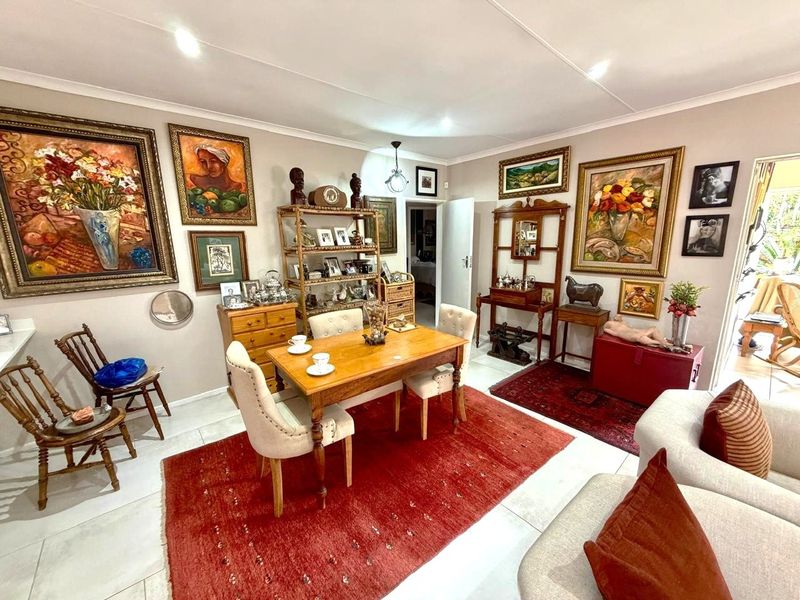 A well-maintained living and dining area featuring neutral wall tones, tiled flooring, and recessed lighting, providing a versatile space for relaxation and entertaining.