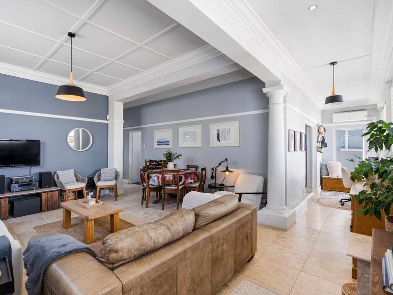 Spacious open-plan living and dining area featuring elegant coffered ceilings, classic architectural columns, and neutral tiled flooring throughout.