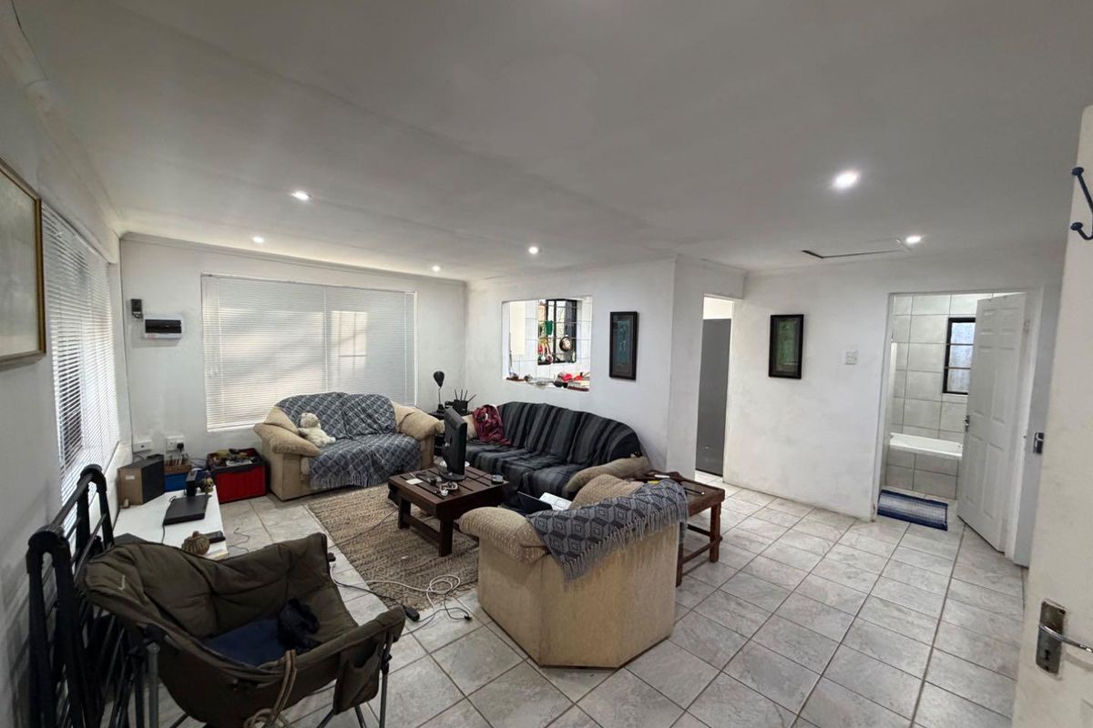 Open-plan living area featuring tiled flooring, recessed downlighting, and direct access to an adjacent bathroom.