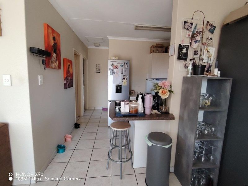 A functional kitchen area featuring tiled flooring and a breakfast bar, providing a practical layout for daily meal preparation and casual dining.