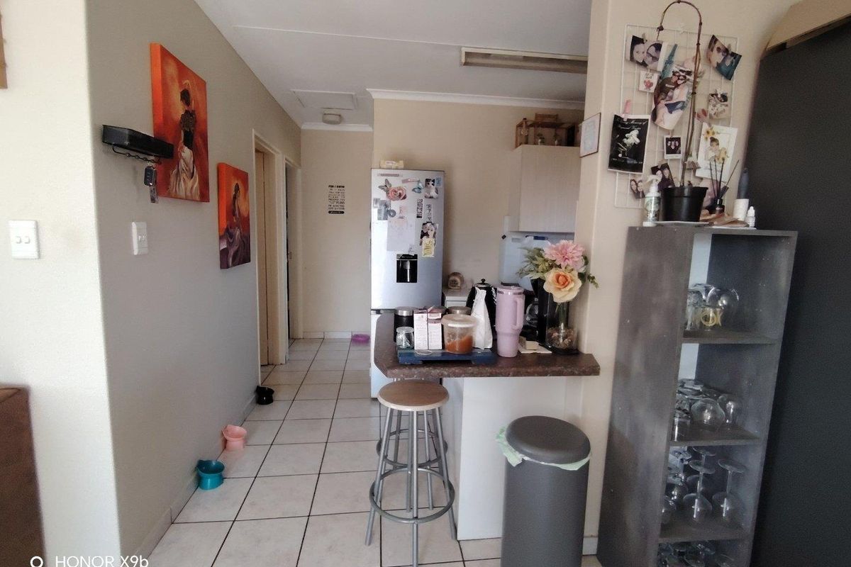 A functional kitchen area featuring tiled flooring and a breakfast bar, providing a practical layout for daily meal preparation and casual dining.
