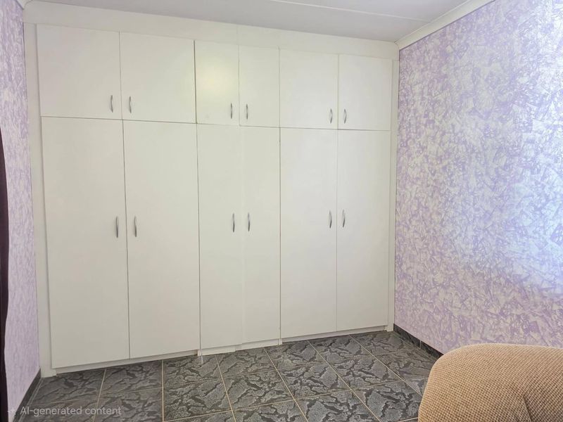 A bedroom featuring extensive white built-in cupboards and tiled flooring, offering ample storage space.