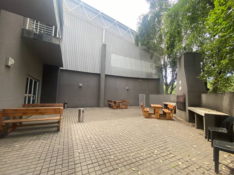 Outdoor paved patio area featuring a built-in braai and concrete counter, suitable for industrial or commercial staff break-out space.