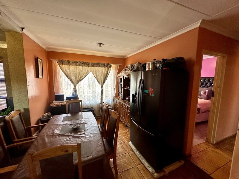 Dining room area featuring tiled flooring and coved ceilings, providing a functional space for family meals.