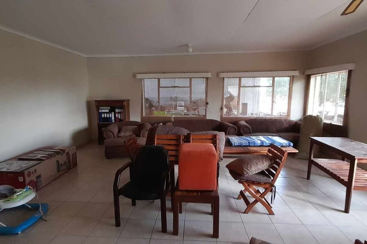 Spacious living area featuring neutral tiled flooring and large windows, offering a versatile layout for comfortable family living.