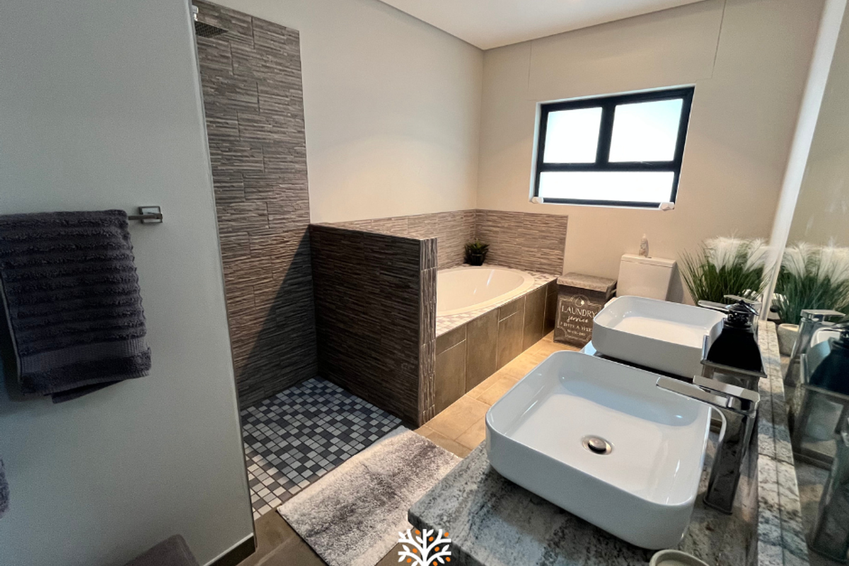 Modern bathroom featuring a double vanity with vessel sinks, a tiled walk-in shower, and a built-in bathtub with stone-look wall cladding.