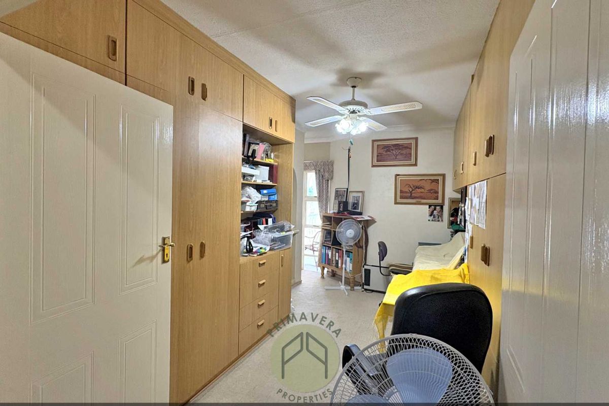 A bedroom featuring extensive built-in wooden cabinetry and storage units, providing ample space for organization and storage.