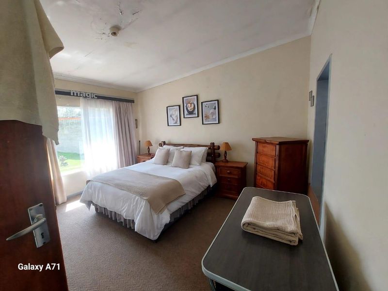 A bedroom featuring carpeted flooring and a sliding glass door, currently showing visible signs of ceiling water damage and wear.