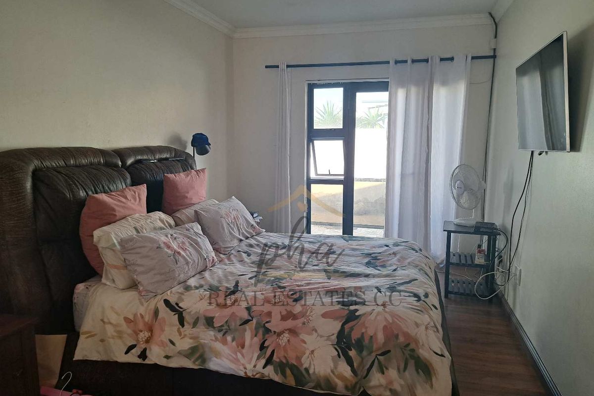 A bedroom featuring laminate flooring, crown molding, and a glass door providing access to the exterior.