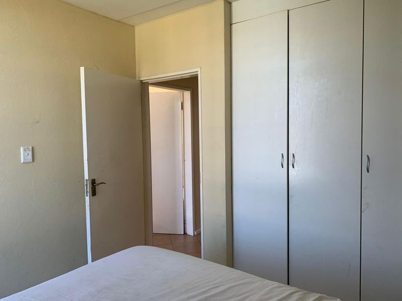 A bedroom featuring built-in cupboards and neutral wall finishes, offering a blank canvas for potential interior updates.
