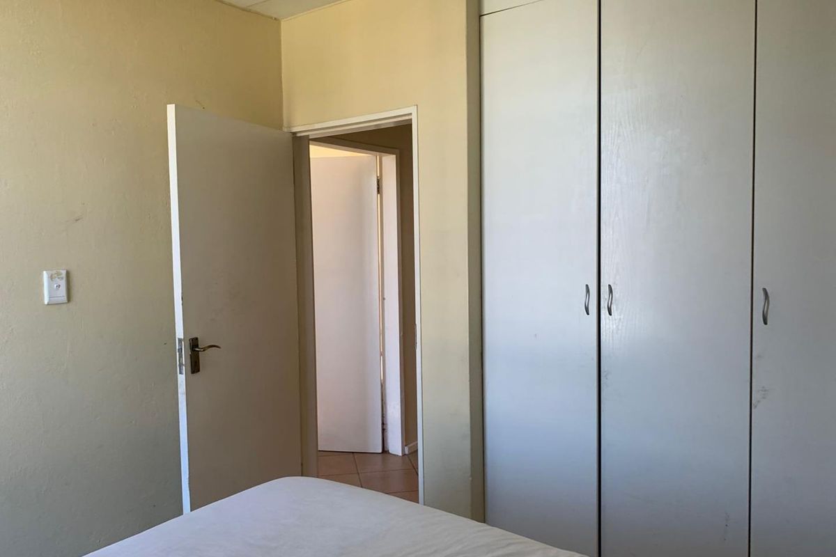 A bedroom featuring built-in cupboards and neutral wall finishes, offering a blank canvas for potential interior updates.