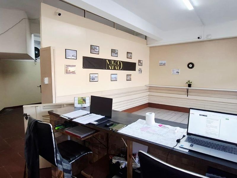 A functional office space featuring a built-in reception counter, tiled flooring, and partition walls, suitable for a professional business environment.