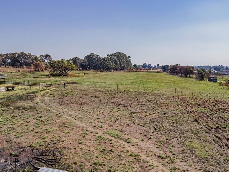 Aerial view of a large small holding property featuring open pasture land, perimeter fencing, and a small outbuilding structure.