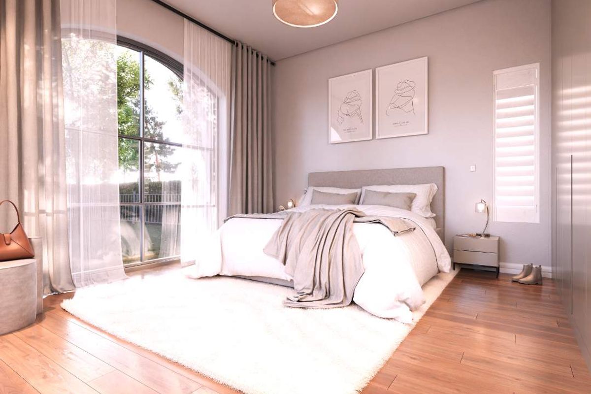 A bright and modern bedroom featuring high-quality timber flooring, an arched window with natural light, and built-in wardrobe storage.