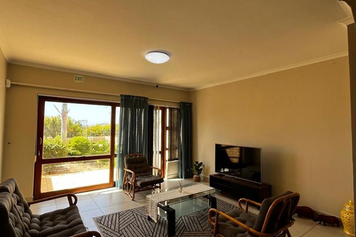 A bright living room featuring large sliding glass doors that provide direct access to the outdoor area and allow for ample natural light.
