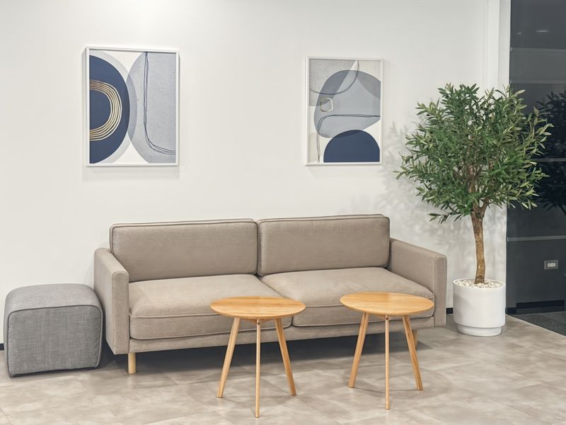 A modern office waiting area featuring neutral tiled flooring and a clean, professional aesthetic.