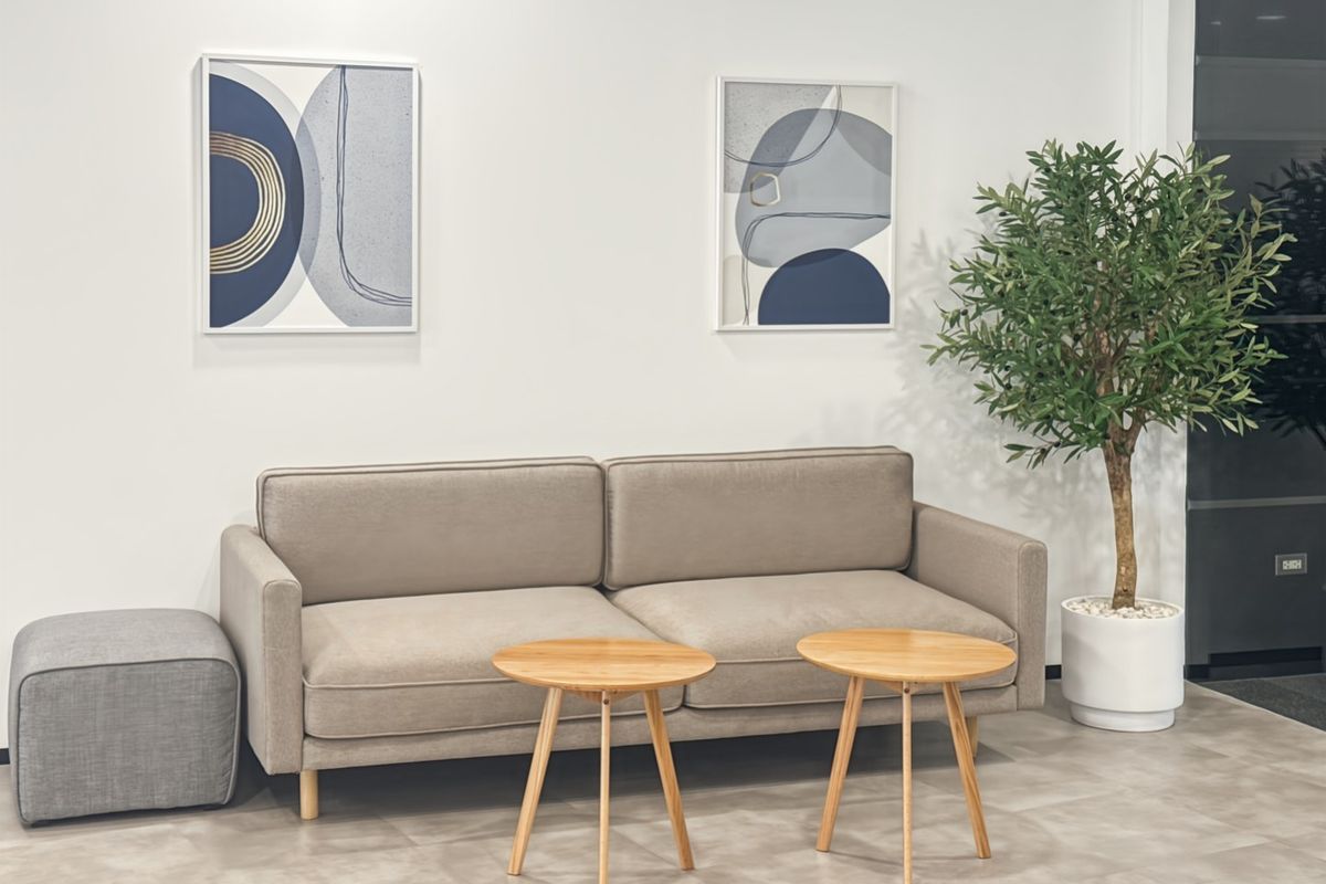 A modern office waiting area featuring neutral tiled flooring and a clean, professional aesthetic.