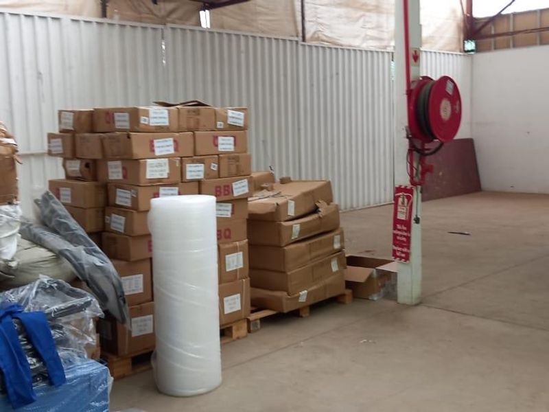Industrial utility space featuring corrugated metal wall cladding, concrete flooring, and a wall-mounted fire hose reel.