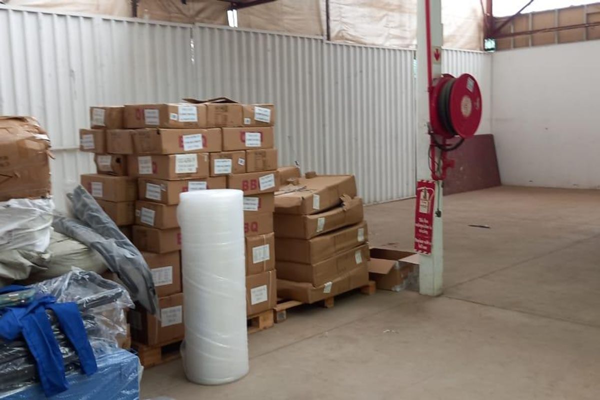 Industrial utility space featuring corrugated metal wall cladding, concrete flooring, and a wall-mounted fire hose reel.