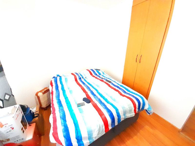 A bedroom featuring laminate flooring and a built-in wooden wardrobe.