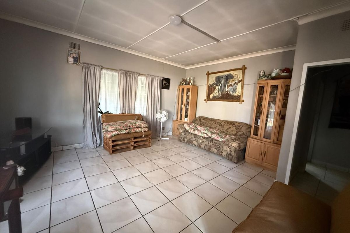 A living room featuring tiled flooring and a tiled ceiling with visible wear, offering a functional space ready for modernization.