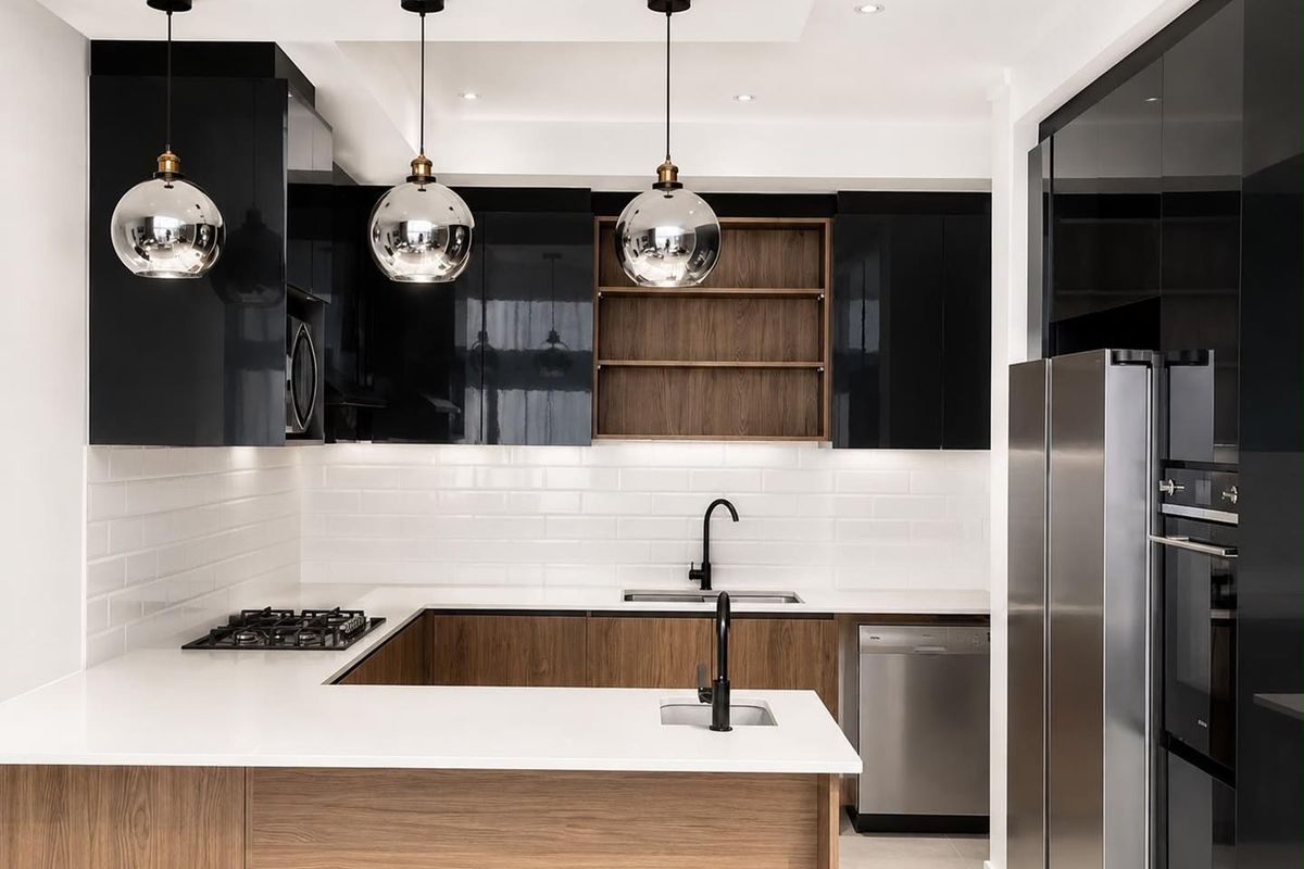 Modern kitchen featuring high-gloss black cabinetry, wood-grain accents, white quartz countertops, subway tile backsplash, and integrated appliances with contemporary pendant lighting.