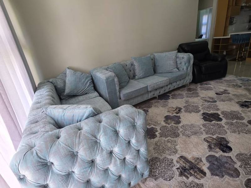 A spacious living room featuring neutral wall tones, tiled flooring, and recessed downlighting, providing a comfortable and well-lit area for relaxation.