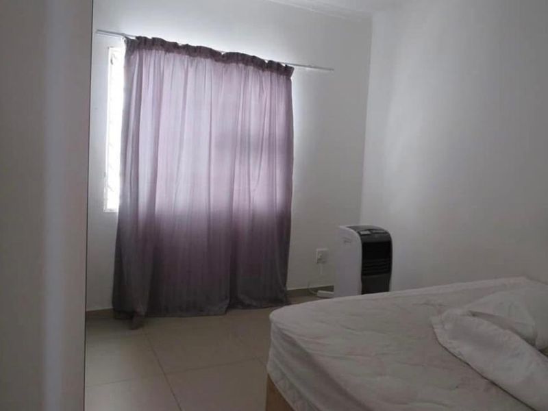 A simple bedroom featuring tiled flooring and a window with a curtain rod, providing a functional and neutral space.