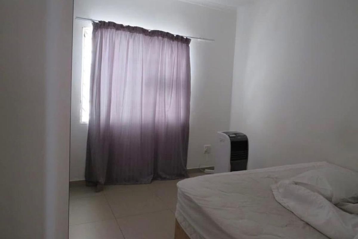 A simple bedroom featuring tiled flooring and a window with a curtain rod, providing a functional and neutral space.