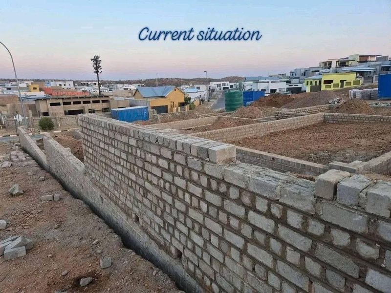 A construction site view showing the initial brickwork and foundation layout for a new townhouse development.