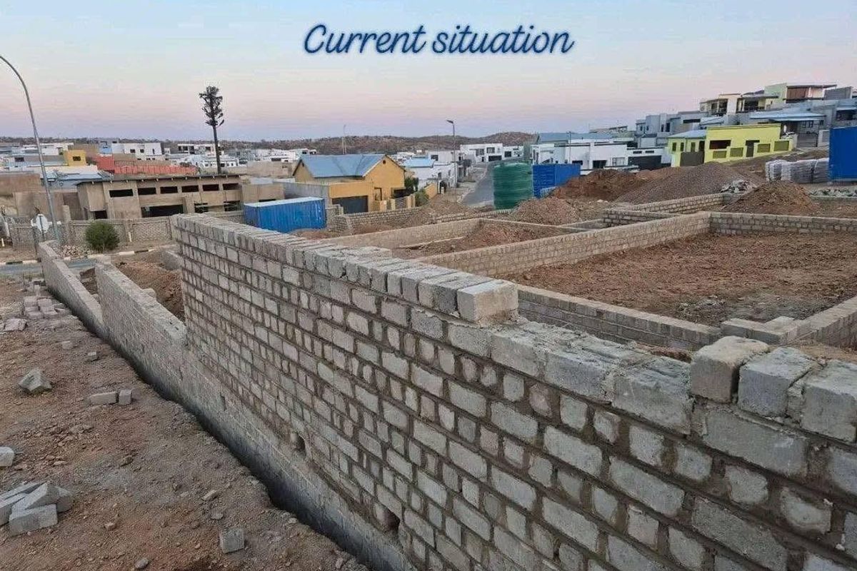 A construction site view showing the initial brickwork and foundation layout for a new townhouse development.