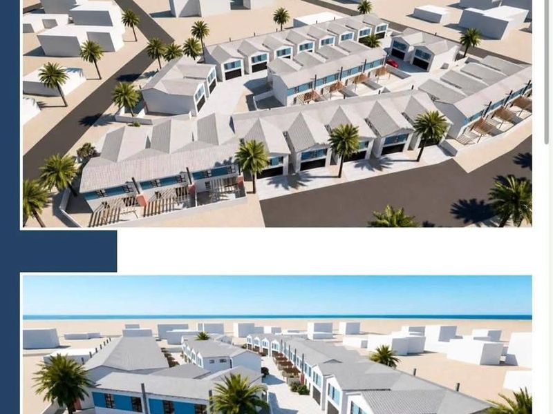 An aerial perspective of a townhouse development featuring multiple units, paved driveways, and landscaped outdoor areas within a secure complex.