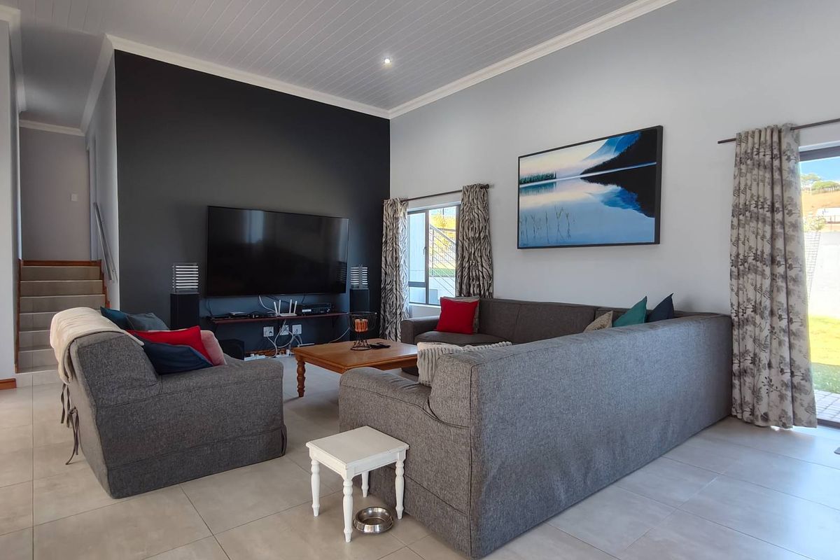 Spacious living room featuring tiled flooring, a feature accent wall, and large sliding glass doors providing direct access to the outdoor area.