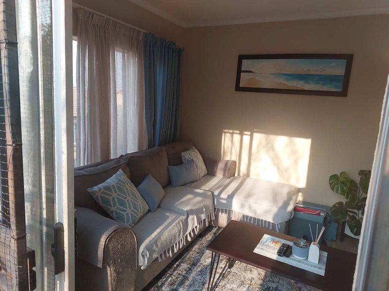 A cozy living room area featuring a large sliding glass door that provides natural light and access to an outdoor space.