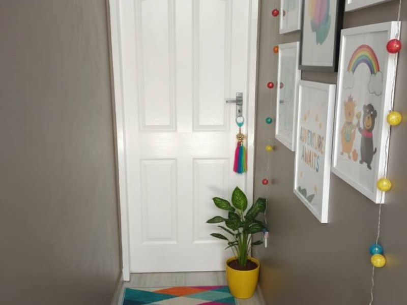 A well-maintained hallway featuring neutral wall tones, tiled flooring, and a classic internal door.