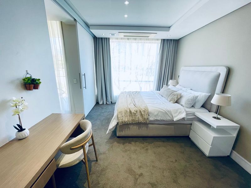 A well-maintained bedroom featuring recessed ceiling lighting, ducted air conditioning, and neutral carpeting, offering a clean and comfortable living space.