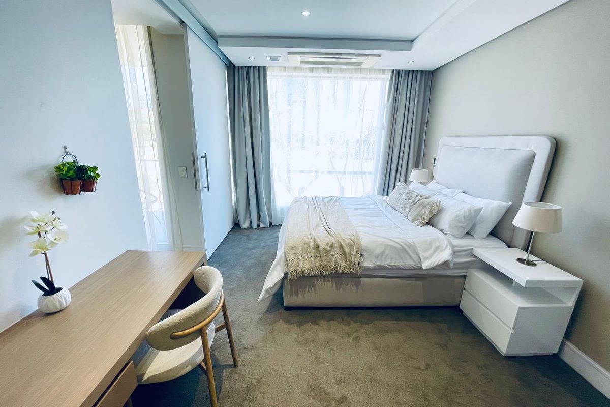 A well-maintained bedroom featuring recessed ceiling lighting, ducted air conditioning, and neutral carpeting, offering a clean and comfortable living space.