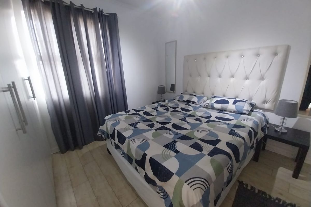 A well-maintained bedroom featuring tiled flooring and built-in cupboards, offering a clean and functional living space.