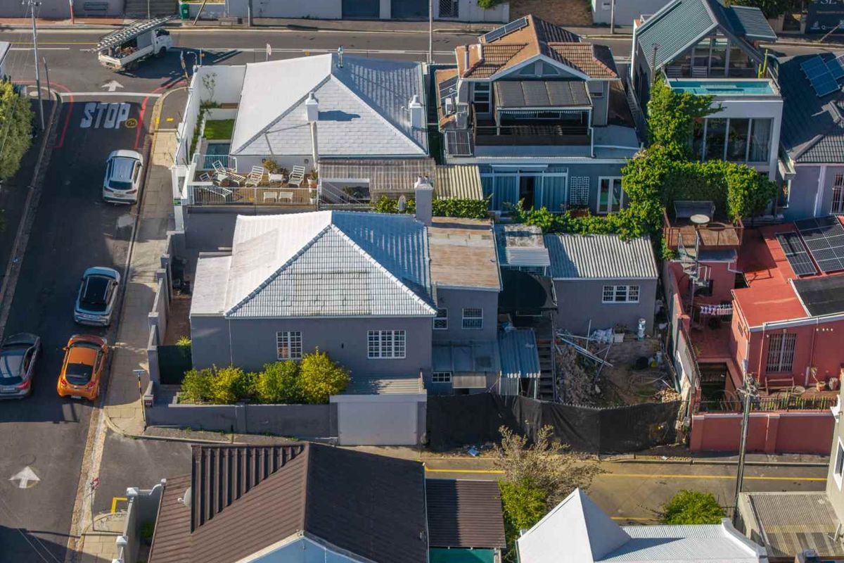 Aerial view of the property showing the roof structure, rear yard area, and surrounding street context in a dense residential neighborhood.