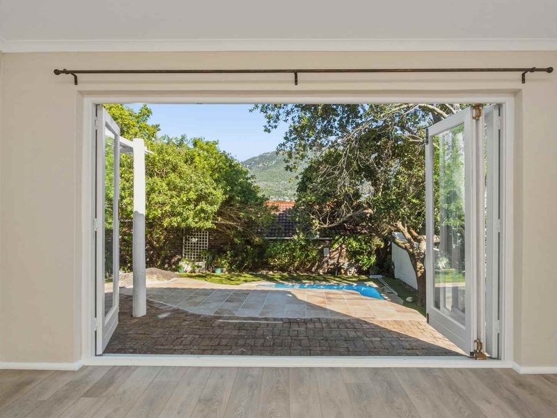 Bright living area featuring wide bi-fold doors that open onto a paved patio and garden area, creating a seamless indoor-outdoor flow.