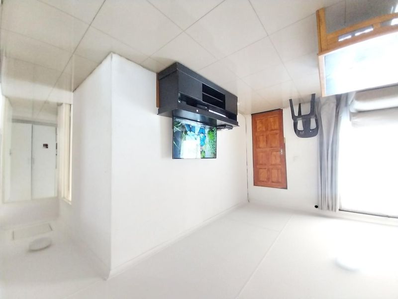 A living room area featuring tiled ceilings and access to an outdoor space via a sliding glass door.