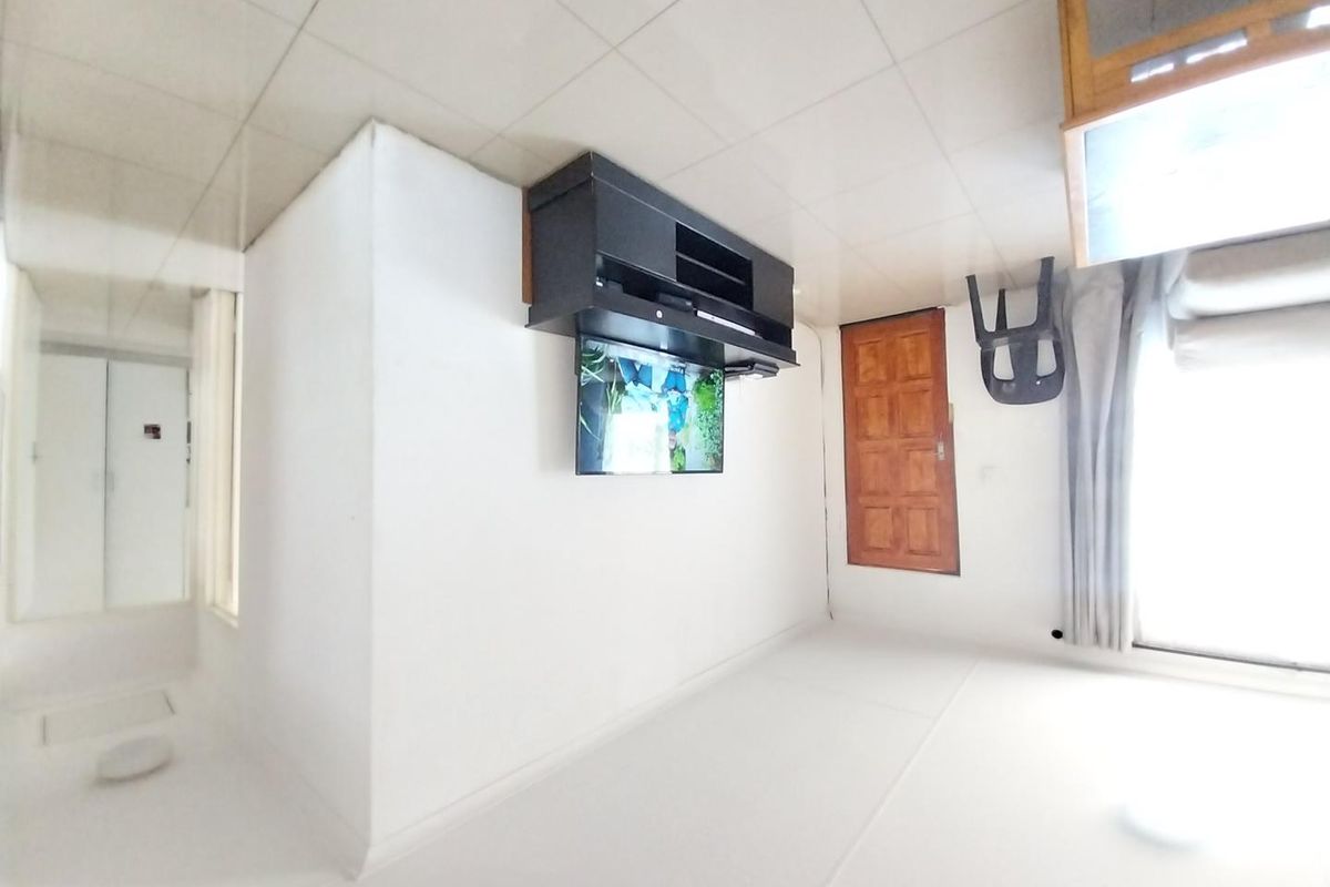 A living room area featuring tiled ceilings and access to an outdoor space via a sliding glass door.