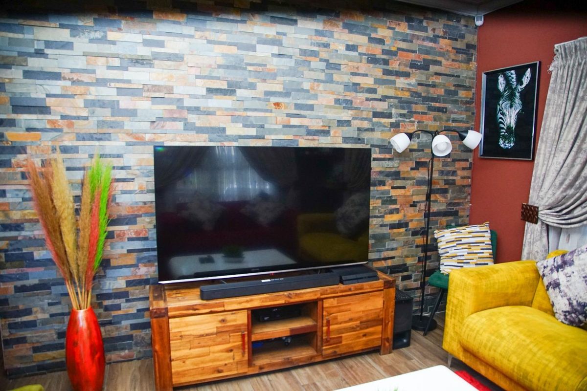 A living room featuring a prominent natural stone feature wall, providing a textured focal point for the space.